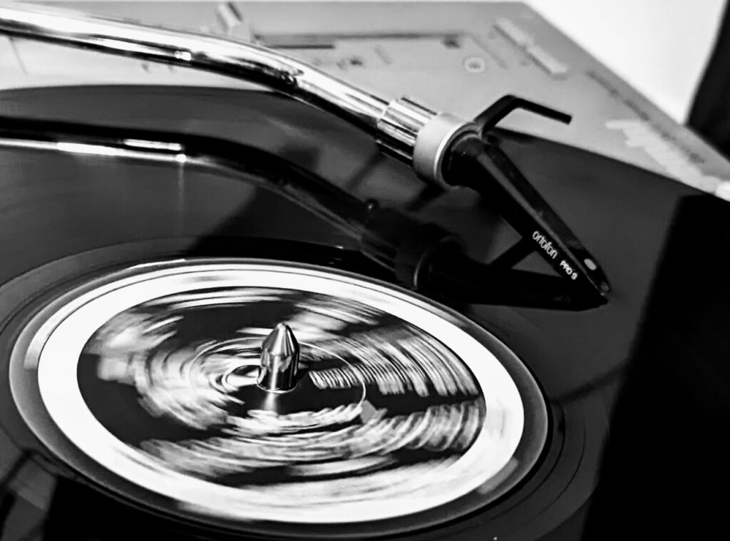 A Vinyl Record being played by on turntable featuring an Ortofon Pro S needle.  